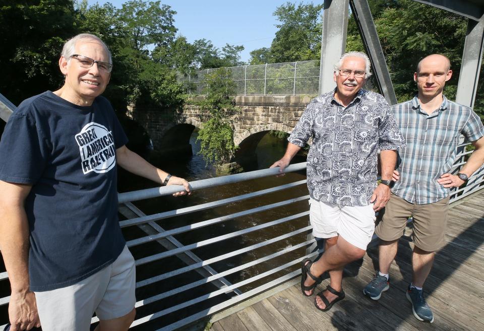 Co-director Bill Sepe, from left, founder and co-director Ron Brubaker and board member Austen Rau discuss on July 26 the stone train bridge as part of a hike/bike trail from Akron to Hudson through Cuyahoga Falls that the group is trying to create.