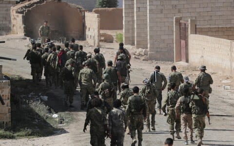 Turkey-backed Syrian rebel fighters walk together near the border town of Tel Abyad, Syri - Credit: REUTERS/Khalil Ashawi