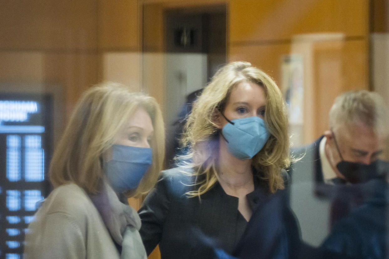 Elizabeth Holmes, center, enters federal court in San Jose, Calif., Monday, Jan. 3, 2022. (AP Photo/Nic Coury)