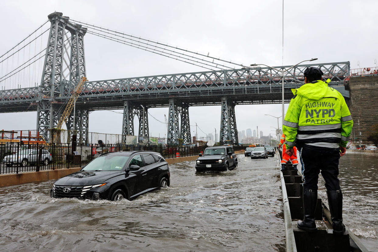 Motorists drive through floodwaters on FDR Drive in Manhattan near the Williamsburg Bridge on Friday, Sept. 29, 2023. (Andrew Kelly / Reuters)