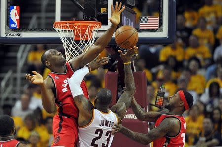 May 19, 2016; Cleveland, OH, USA; Cleveland Cavaliers forward LeBron James (23) shoots the ball as Toronto Raptors center Bismack Biyombo (8) and forward Terrence Ross (31) defend during the second quarter in game two of the Eastern conference finals of the NBA Playoffs at Quicken Loans Arena. Mandatory Credit: Ken Blaze-USA TODAY Sports