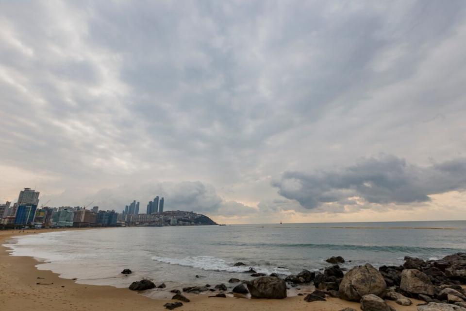 遊客可以在海雲台海灘鋪上墊子，坐下來欣賞美麗的海岸線，以及聆聽海浪拍打的聲音。圖/123RF圖庫