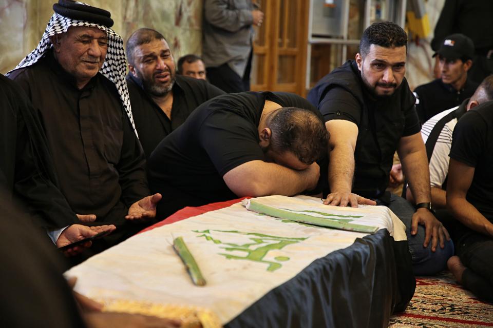 Mourners pray over the flag-draped coffin of a protester killed during anti-government protesters during his funeral at the Imam Ali shrine in Najaf, Iraq, Saturday, Oct. 5, 2019. The spontaneous protests which started Tuesday in Baghdad and southern cities were sparked by endemic corruption and lack of jobs. Security responded with a harsh crackdown, leaving more than 70 killed. (AP Photo/Anmar Khalil)