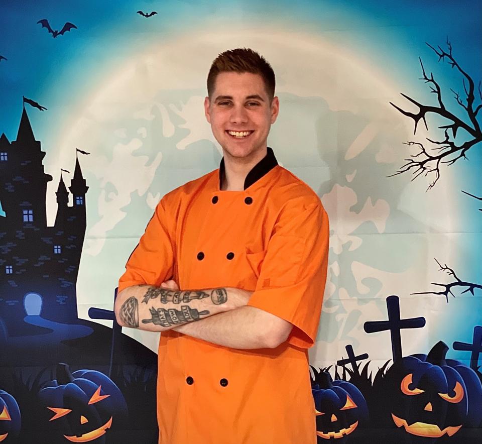Local pastry chef and York native Hunter Roof poses with orange Baker's jacket for Halloween Challenge in 2021.