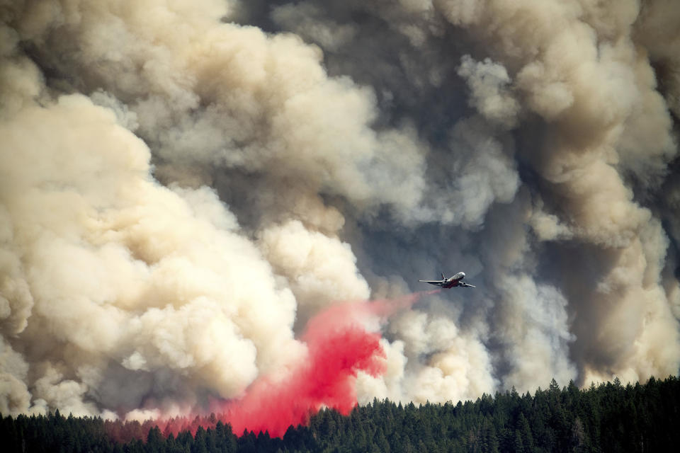 Viewed from the Foresthill community in Placer County, Calif., an air tanker drops retardant on the Mosquito Fire as it burns near Volcanoville on Thursday, Sept. 8, 2022. (AP Photo/Noah Berger)