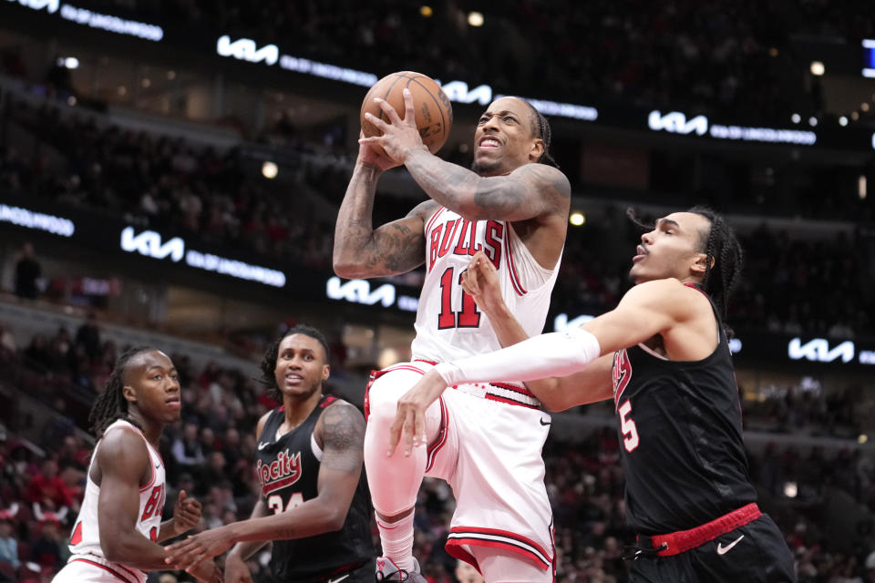 Chicago Bulls' DeMar DeRozan (11) drives to the basket and is fouled by Portland Trail Blazers' Dalano Banton, right, during the first half of an NBA basketball game Monday, March 18, 2024, in Chicago. (AP Photo/Charles Rex Arbogast)