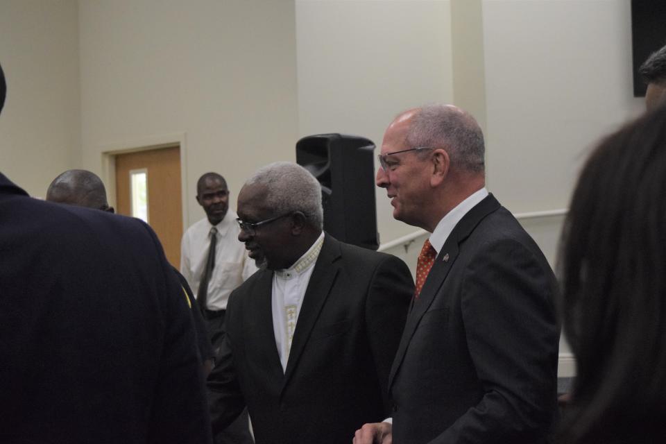 Mt. Pleasant Baptist Church Rev. Gerald Toussint, left, and Louisiana Gov. John Bel Edwards, talk with church congregants after the church, which was destroyed by fire in 2019, reopens on Dec. 8, 2022.