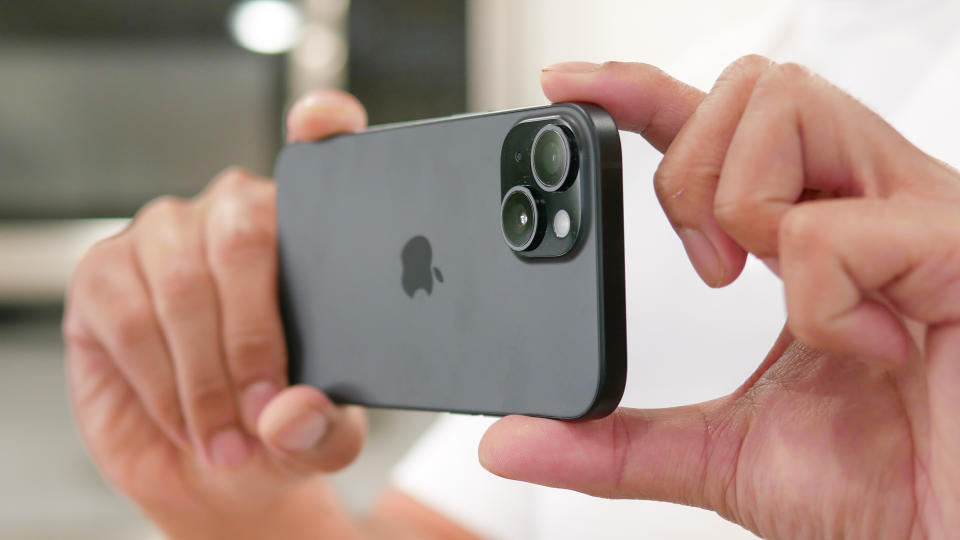 Guy taking a photo using the Apple iPhone 15.