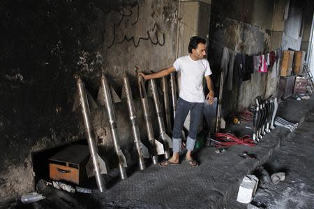 A man stands next to locally made shells belonging to the Free Syrian Army beside the Canadian Hospital in Aleppo, August 31, 2013. REUTERS/Molhem Barakat