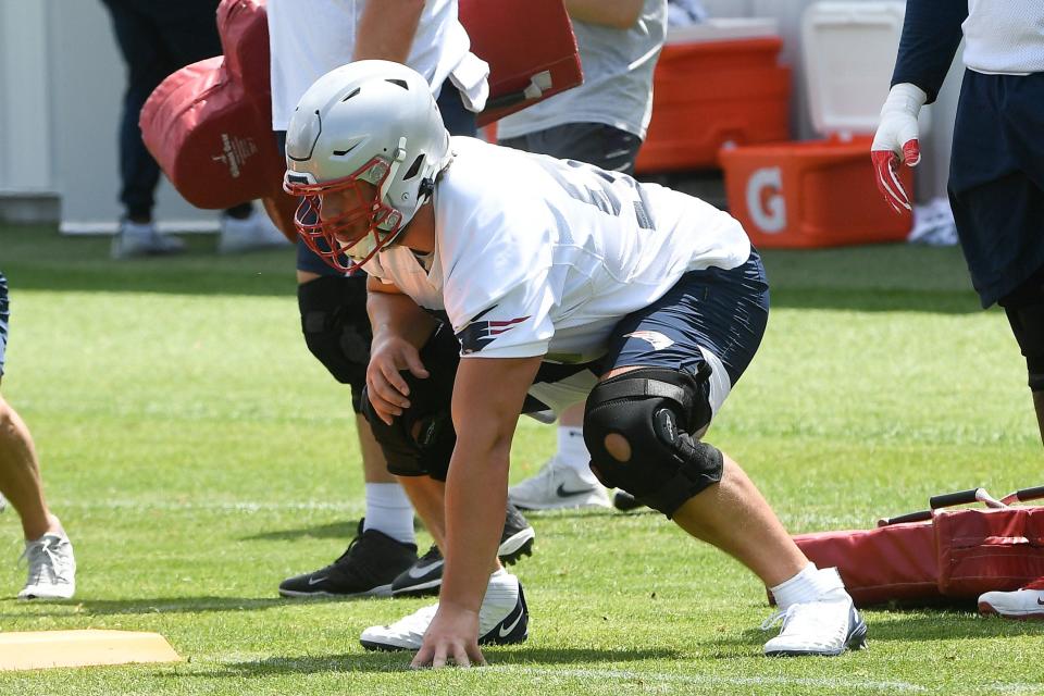 The Patriots' first-round draft pick, offensive lineman Cole Strange, lines up in a three-point stance for a drill during OTAs in May.