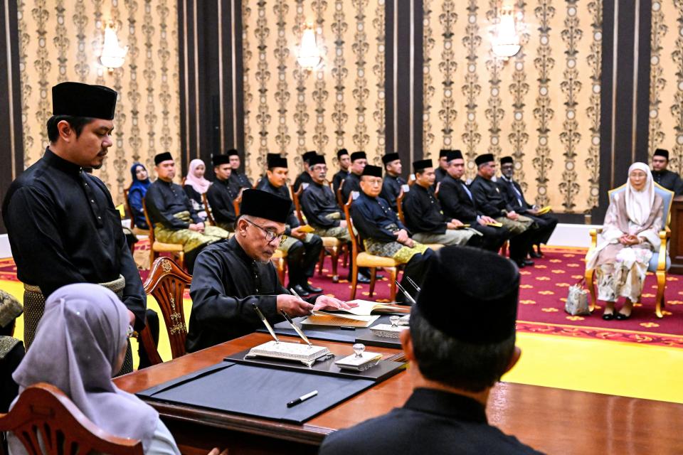 Malaysia's newly appointed Prime Minister Anwar Ibrahim, second left, takes the oath of office during his swearing-in ceremony as the country's 10th prime minister at the National Palace in Kuala Lumpur, Malaysia, Thursday, Nov. 24, 2022. (Mohd Rasfan/Pool Photo via AP)