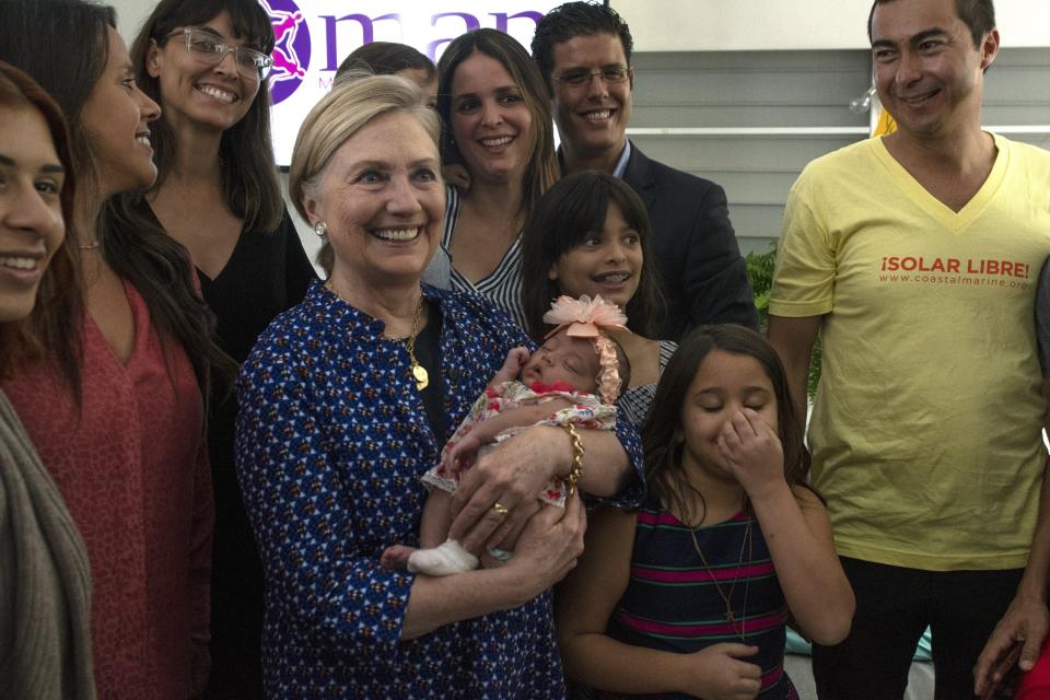 Clinton with client families and workers at Centro MAM