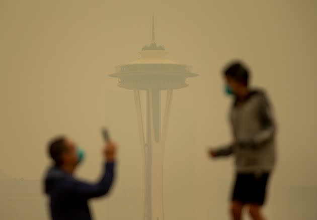 People take photos against the backdrop of the Space Needle as smoke from wildfires fills the air at Kerry Park on Sept. 12, 2020, in Seattle, Washington. (Photo: Lindsey Wasson via Getty Images)