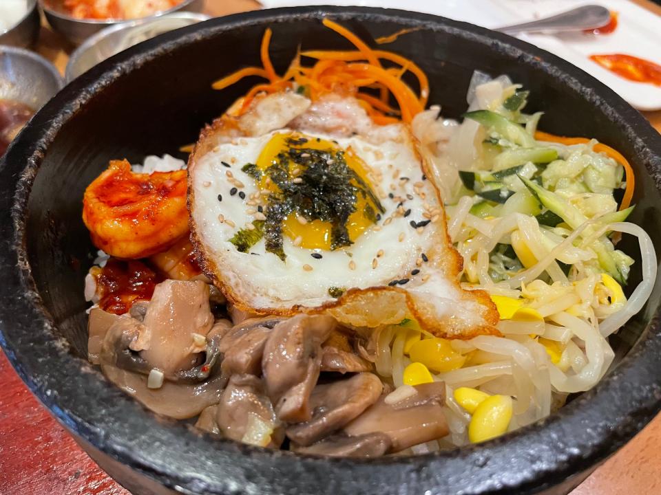 The K Mixed Rice section features four bibimbap dishes. Pictured here is the spicy shrimp with a variety of vegetables, all served over fried rice and an added fried egg.