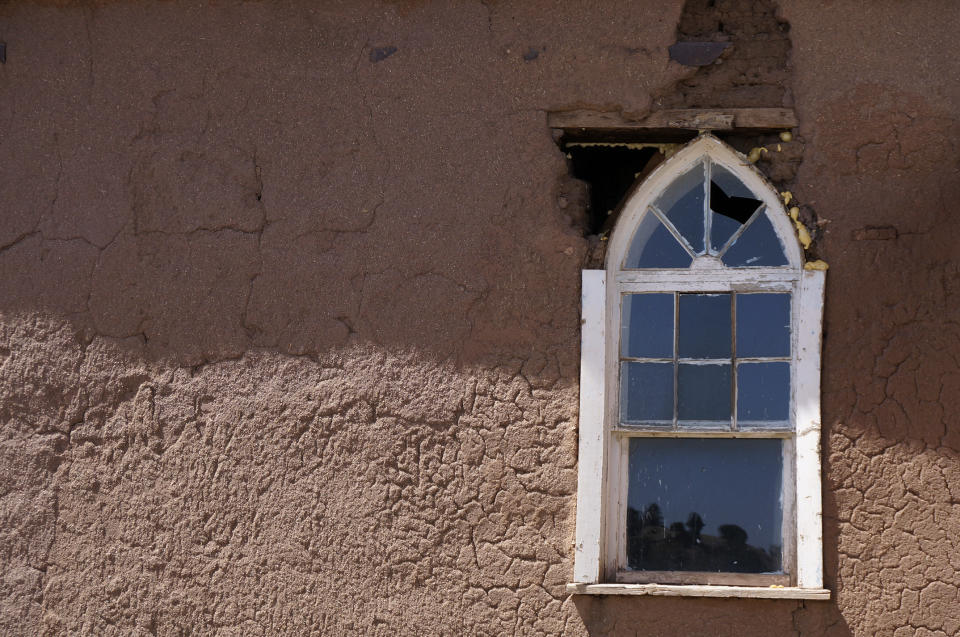 A gaping hole in the adobe wall allows insects and other pests to enter the church of San Geronimo in a remote valley, west of Las Vegas, New Mexico, Saturday, April 15, 2023. The 1840s church built of mud bricks in a nearly abandoned village is in danger of collapsing, as are many remote chapels in this rural area with dwindling congregations and chronic poverty. (AP Photos/Giovanna Dell'Orto)