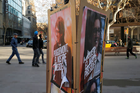 People walk past posters of pro-independence politicians in Barcelona, Spain, December 22, 2017. REUTERS/Jon Nazca