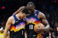 Phoenix Suns guard Devin Booker (1) is congratulated by center Bismack Biyombo (18) after scoring against the Indiana Pacers during the second half of an NBA basketball game Saturday, Jan. 22, 2022, in Phoenix. (AP Photo/Ross D. Franklin)