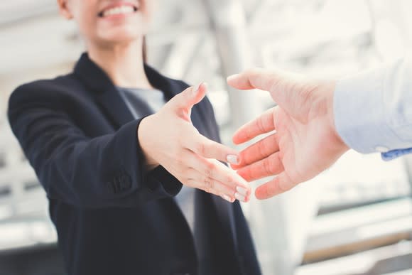 Businesswoman holds out her hand for a handshake.