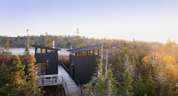 Greg Knapp and Robyn Traynor worked with architect Peter Braithwaite to design a nature retreat for their family on a slice of Canadian wilderness. It has two shed-roofed structures joined by a boardwalk elevated above a pre-existing walking path on the couple’s land.