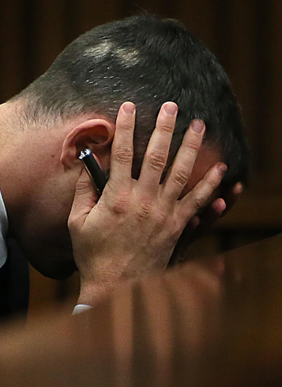 Oscar Pistorius holds his head in his hands as he listens to evidence being given in court in Pretoria, South Africa, Tuesday, April 15, 2014 after questioning by state prosecutor Gerrie Nel, had earlier finished. Pistorius is charged with the murder of his girlfriend Reeva Steenkamp, on Valentines Day in 2013. (AP Photo/Alon Skuy, Pool)