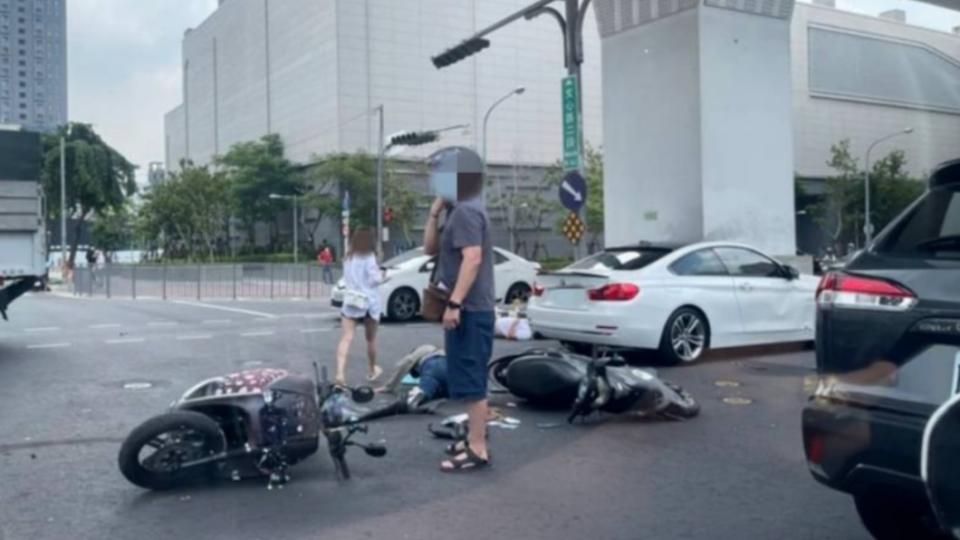 白色BMW疑似違規左轉，導致2騎士接連重摔倒地。（圖／翻攝自記者爆料網）