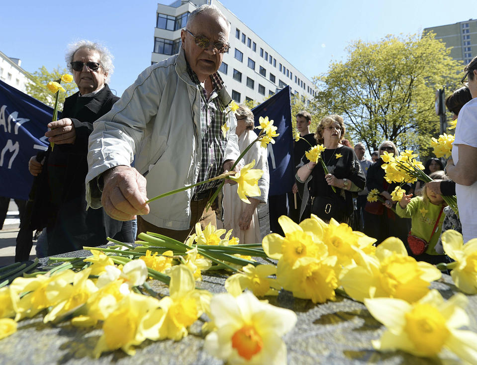 Warsaw residents lay daffodils, which have become the symbol of remembrance of the 1943 Warsaw Ghetto Uprising against the German Nazi, at a memorial site of the struggle, during anniversary observances in Warsaw, Poland, Friday, April 19, 2019.(AP Photo/Czarek Sokolowski)