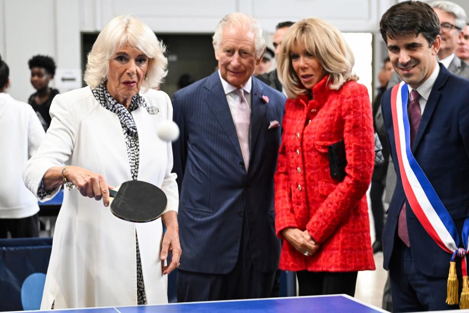 A bemused Queen Camilla plays a game of ping-pong in Saint-Denis (AP)