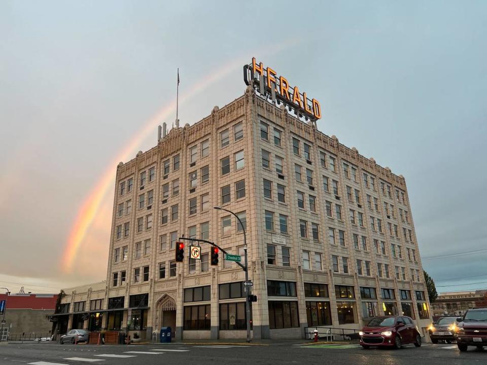 A rainbow arcs above the Herald Building at the corner of North State and East Chestnut streets in Bellingham, Wash., on Oct 19, 2023. Built in 1926, the six-story Gothic Revival building uses white terra cotta tiles and stained glass windows depicting a herald playing a trumpet. The building was the first in downtown Bellingham to use a concrete-and-steel form and steam for heating. It’s on the National Register of Historic Places. Robert Mittendorf/The Bellingham Herald