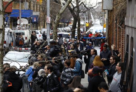 Members of the media stand outside the apartment of movie actor Philip Seymour Hoffman after he was found dead in New York February 2, 2014. REUTERS/Joshua Lott