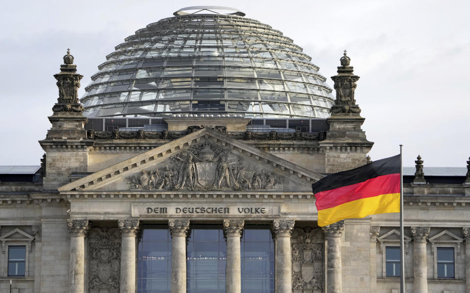 FILE - A national flag of Germany waves in front of the Reichag building, home of the German federal parliament Bundestag, in Berlin, Germany, on Jan. 3, 2022. German lawmakers have approved legislation easing rules to gain citizenship and ending restrictions on holding dual citizenship. (AP Photo/Michael Sohn, File)
