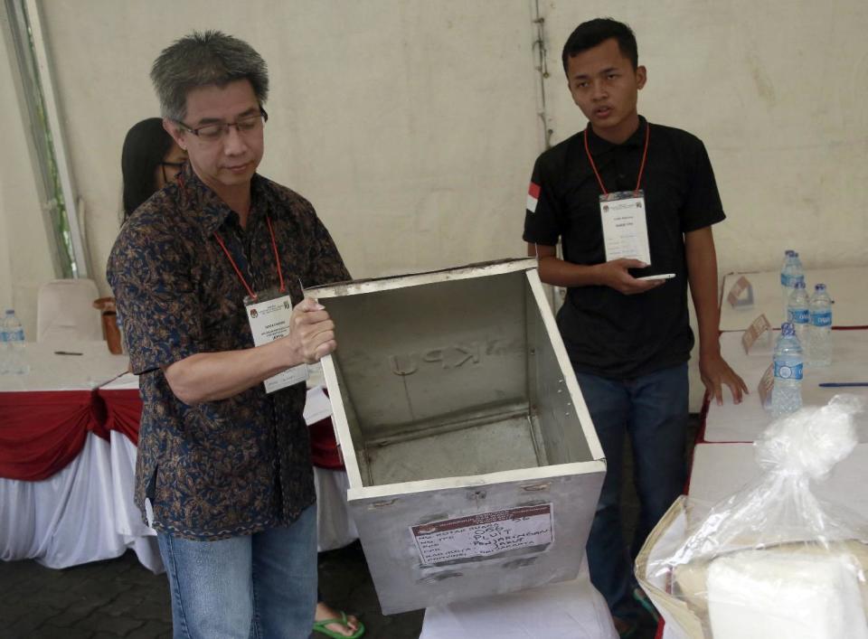 An official shows an empty ballot box before opening the polling station for voters during the gubernatorial election in Jakarta, Indonesia, Wednesday, Feb. 15, 2017. Voting was underway in the election for governor of the Indonesian capital after a divisive months-long campaign in which the monumental problems facing Jakarta took a backseat to religious intolerance and racial bigotry. (AP Photo/Dita Alangkara)