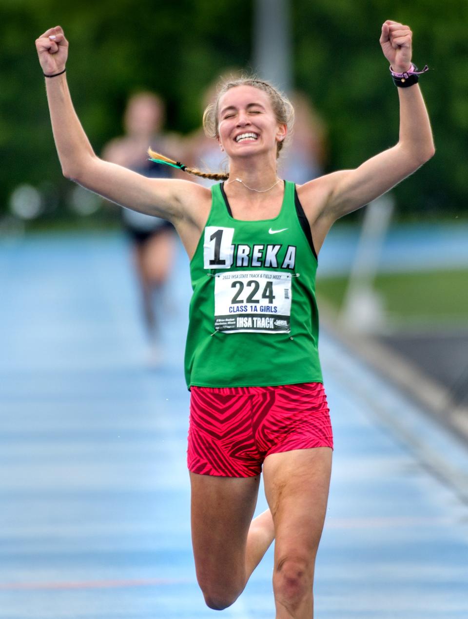 Eureka's Anna Perry raises her arms in triumph as she crosses the finish line to victory in the 3200-meter run in the Class 1A State Track and Field Championships on Saturday, May 21, 2022 at Eastern Illinois University.