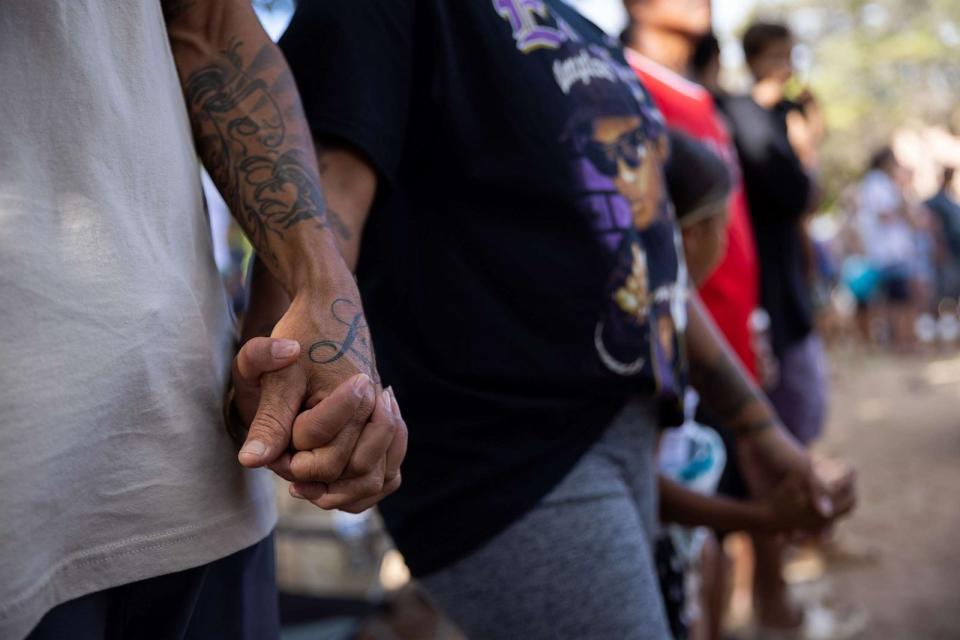 PHOTO: Eric and Lei Casco, whose apartment in Lahaina, HI, was destroyed in the Aug. 8 wildfires, hold hands as they attend a community-organized concert supporting those impacted by the fires at Honokowai Beach Park near Lahaina on Aug. 27, 2023. (Tamir Kalifa for The Washington Post via Getty Images)