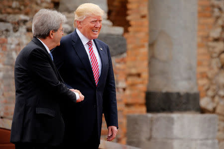 U.S. President Donald Trump (R) is greeted by Italy's Prime Minister Paolo Gentiloni before a family photo at the start of G7 Summit at Greek Theatre in Taormina, Sicily, Italy, May 26, 2017. REUTERS/Jonathan Ernst