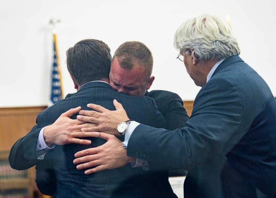 Michael Mattioli (center) hugs attorney Craig S. Powell (left). Attorney Michael F. Hart is on the right. Mattioli was acquitted of first-degree reckless homicide of Joel Acevedo in a jury trial Friday, Nov. 10, 2023 in Milwaukee.