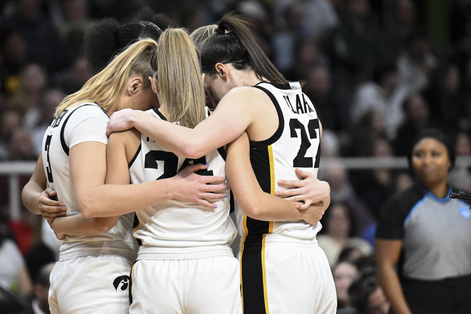 Iowa guard Caitlin Clark (22) huddles with teammates on the court before playing LSU in an Elite Eight round college basketball game during the NCAA Tournament, Monday, April 1, 2024, in Albany, N.Y. (AP Photo/Hans Pennink)