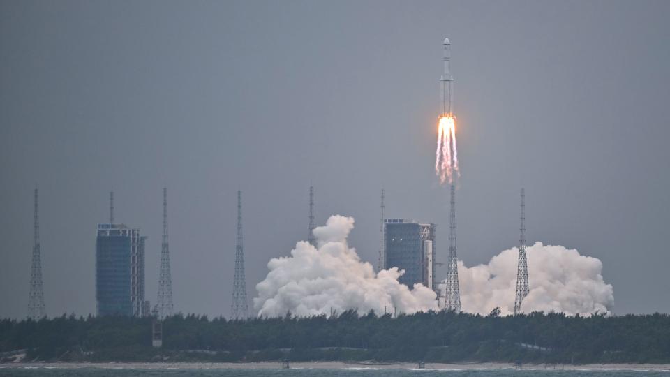 a white rocket lifts off through a greyish-blue sky