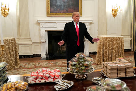 U.S. President Donald Trump speaks in front of fast food provided for the 2018 College Football Playoff National Champion Clemson Tigers due to the partial government shutdown in the State Dining Room of the White House in Washington, U.S., January 14, 2019. REUTERS/Joshua Roberts