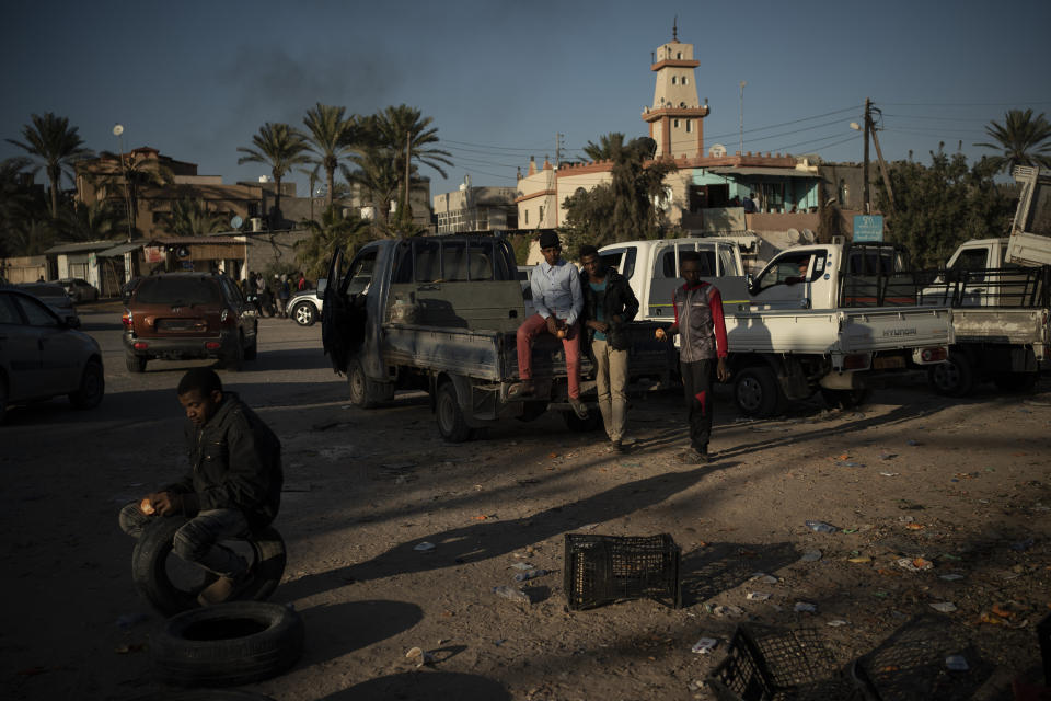 Migrants from Niger looking for jobs wait at an intersection in the outskirts of Tripoli, Libya, on Feb. 27, 2020. (AP Photo/Felipe Dana)