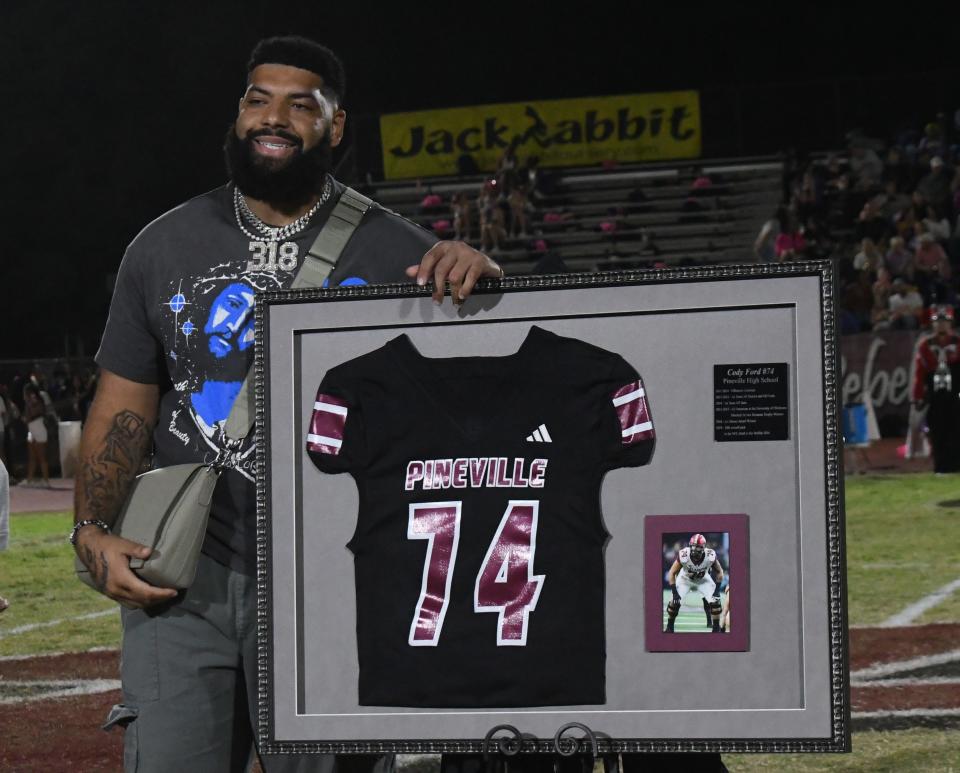 Cincinnati Bengals player Cody Ford and Pineville High School alum smiles after his Pineville jersey number 74 was retired in a ceremony held during halftime of the Red River Rivalry between Pineville and Alexandria Senior High School on Friday.