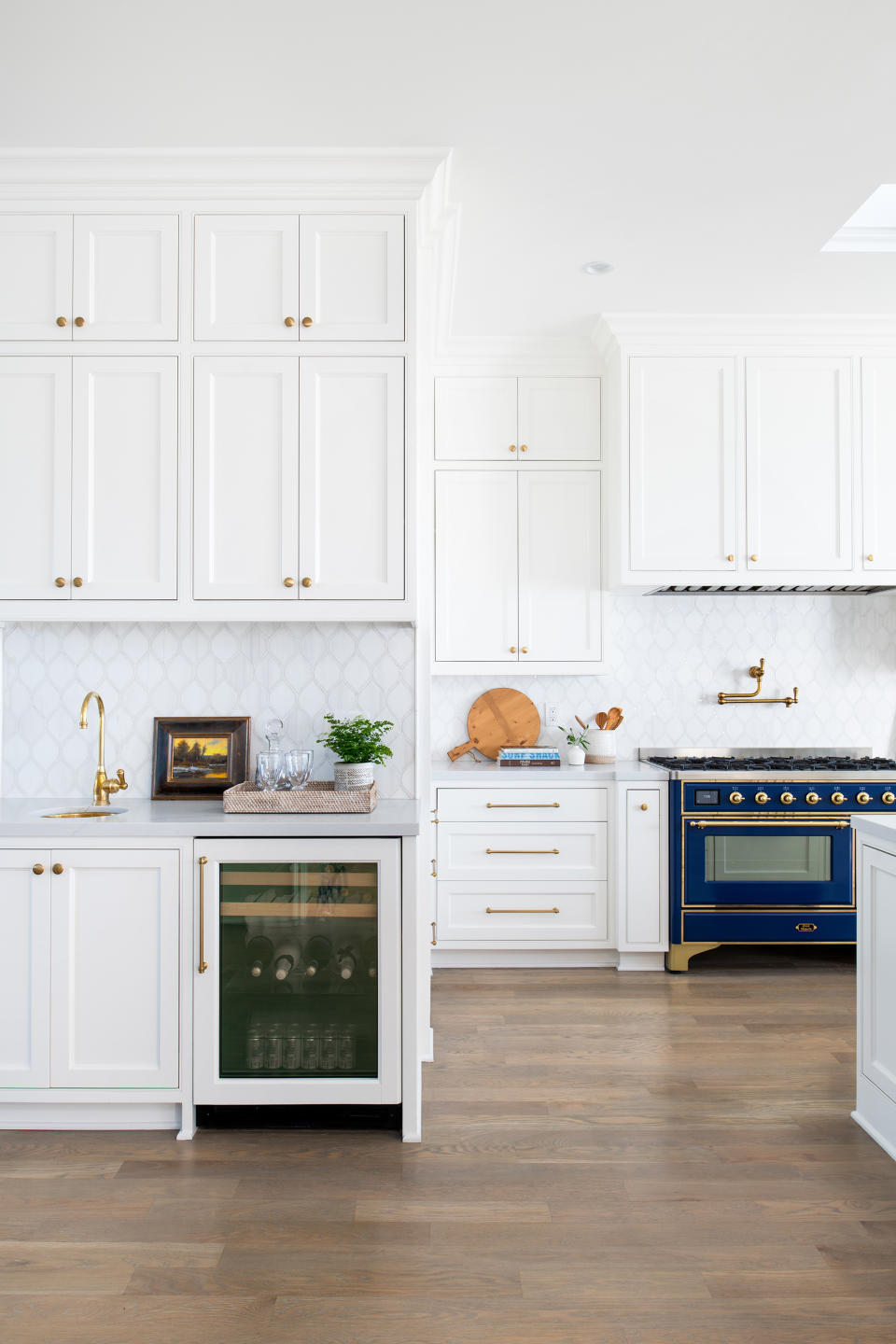 kitchen with white cabinetry, light wood flooring and navy blue iliv stove