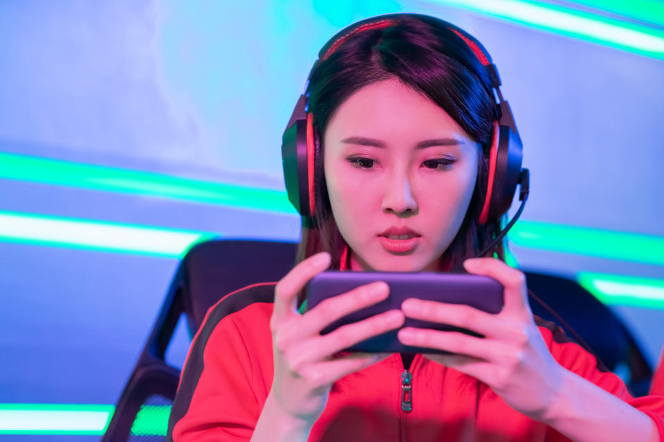 Close Up of young asian teenage cyber sport gamer play mobile game by smartphone on eSport tournament