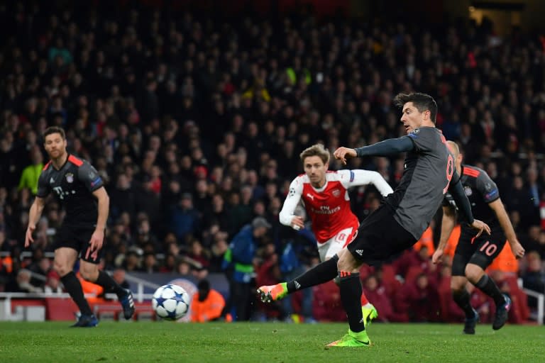 Bayern Munich's forward Robert Lewandowski (R) scores from a penalty during the UEFA Champions League last 16 second leg football match between Arsenal and Bayern Munich at The Emirates Stadium in London on March 7, 2017