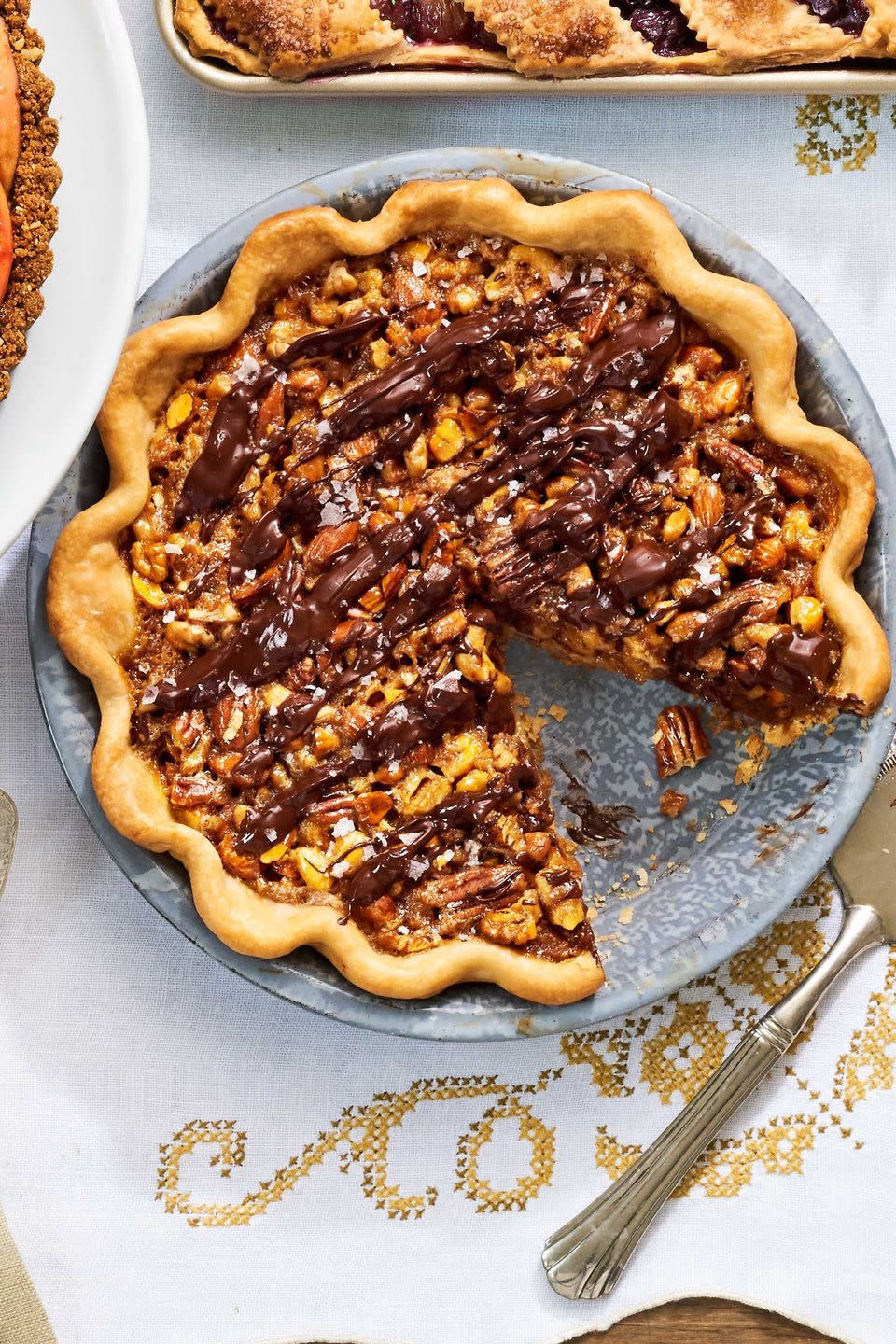 maple nut pie in a metal pie dish with a slice removed