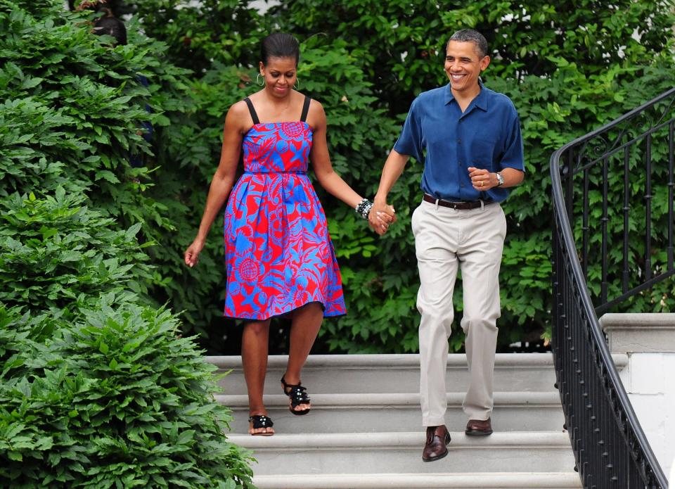 Michelle and Barack Obama at a 4th of July event at the White House. Michelle Obama wears a red and blue dress.