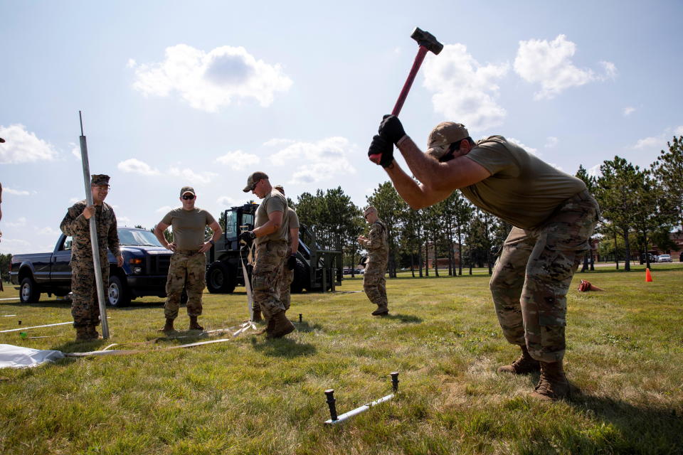 U.S. Marine and U.S. Air National Guard work to raise reception tents for the arrival of Afghan evacuees at Volk Field Air National Guard Base in Wisconsin on August 19, 2021. / Credit: U.S. Army/1st Sgt. Michel Sauret/Handout via REUTERS