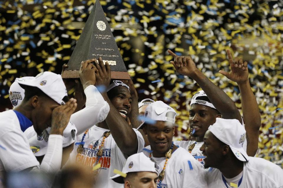 Florida center Patric Young (4) hills the SEC Championship trophy with his team mates after the second half of an NCAA college basketball game against Kentucky in the Championship round of the Southeastern Conference men's tournament, Sunday, March 16, 2014, in Atlanta. Florida won 61-60. (AP Photo/John Bazemore)