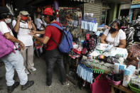 Men buy face masks to help curb the spread of the COVID-19 in Caloocan city, Philippines on Wednesday, Aug. 19, 2020. Philippine President Rodrigo Duterte has decided to ease a mild coronavirus lockdown in the capital and four outlying provinces to further reopen the country's battered economy despite having the most reported infections in Southeast Asia. (AP Photo/Aaron Favila)