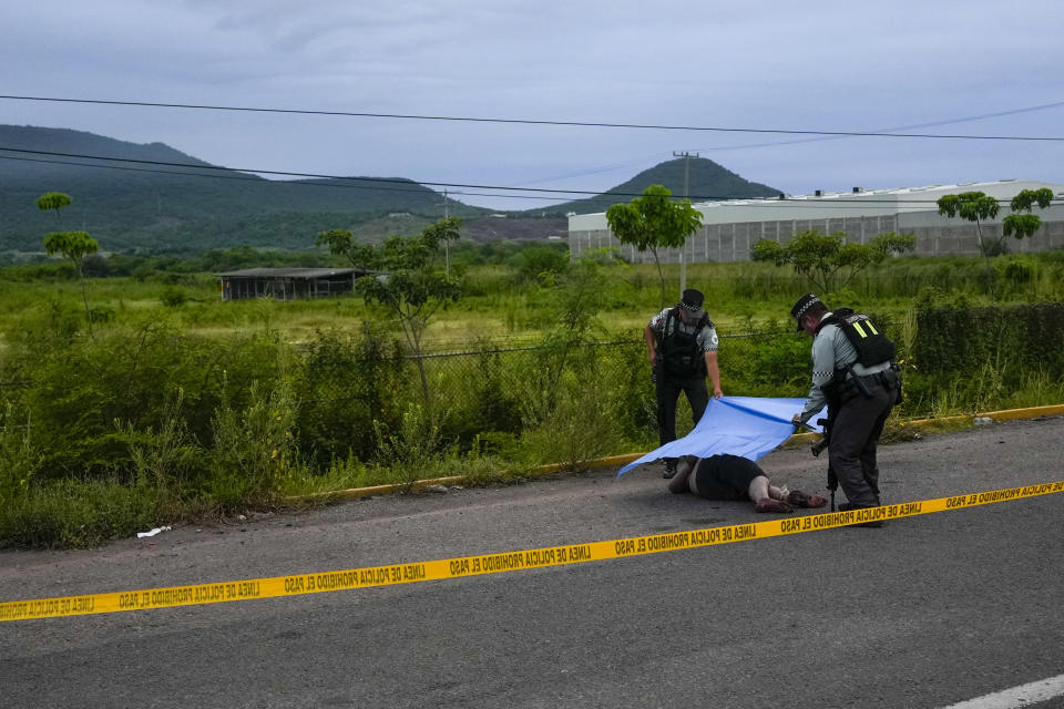 FILE - Mexican National Guardsmen cover a body found lying on the side of a road in Culiacan, Sinaloa state, Mexico, Sept. 21, 2024. (AP Photo/Eduardo Verdugo, File)