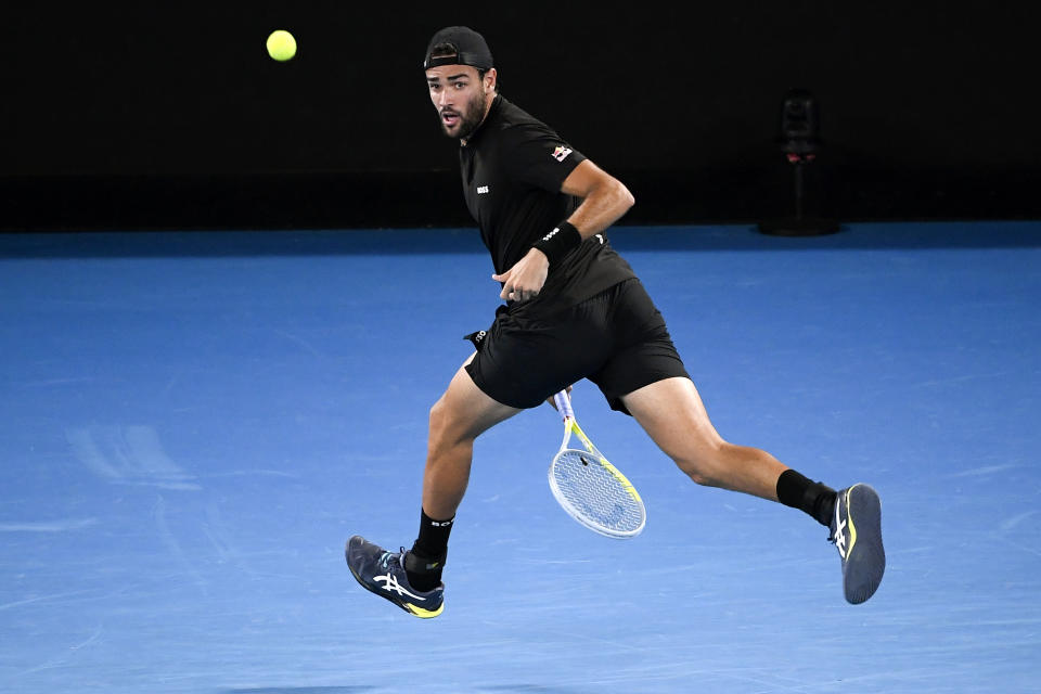 Matteo Berrettini of Italy plays a shot between his legs to Gael Monfils of France during their quarterfinal match at the Australian Open tennis championships in Melbourne, Australia, Tuesday, Jan. 25, 2022. (AP Photo/Andy Brownbill)